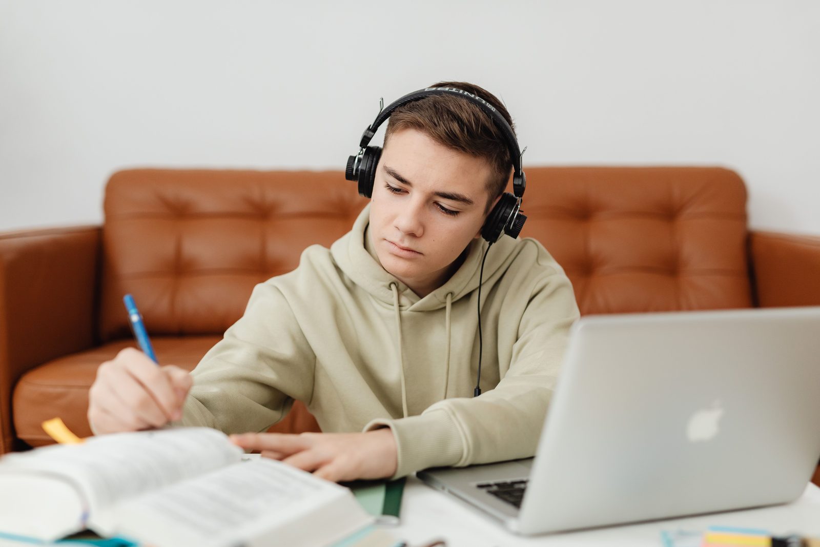 Teenager revising with a laptop and notes, focused