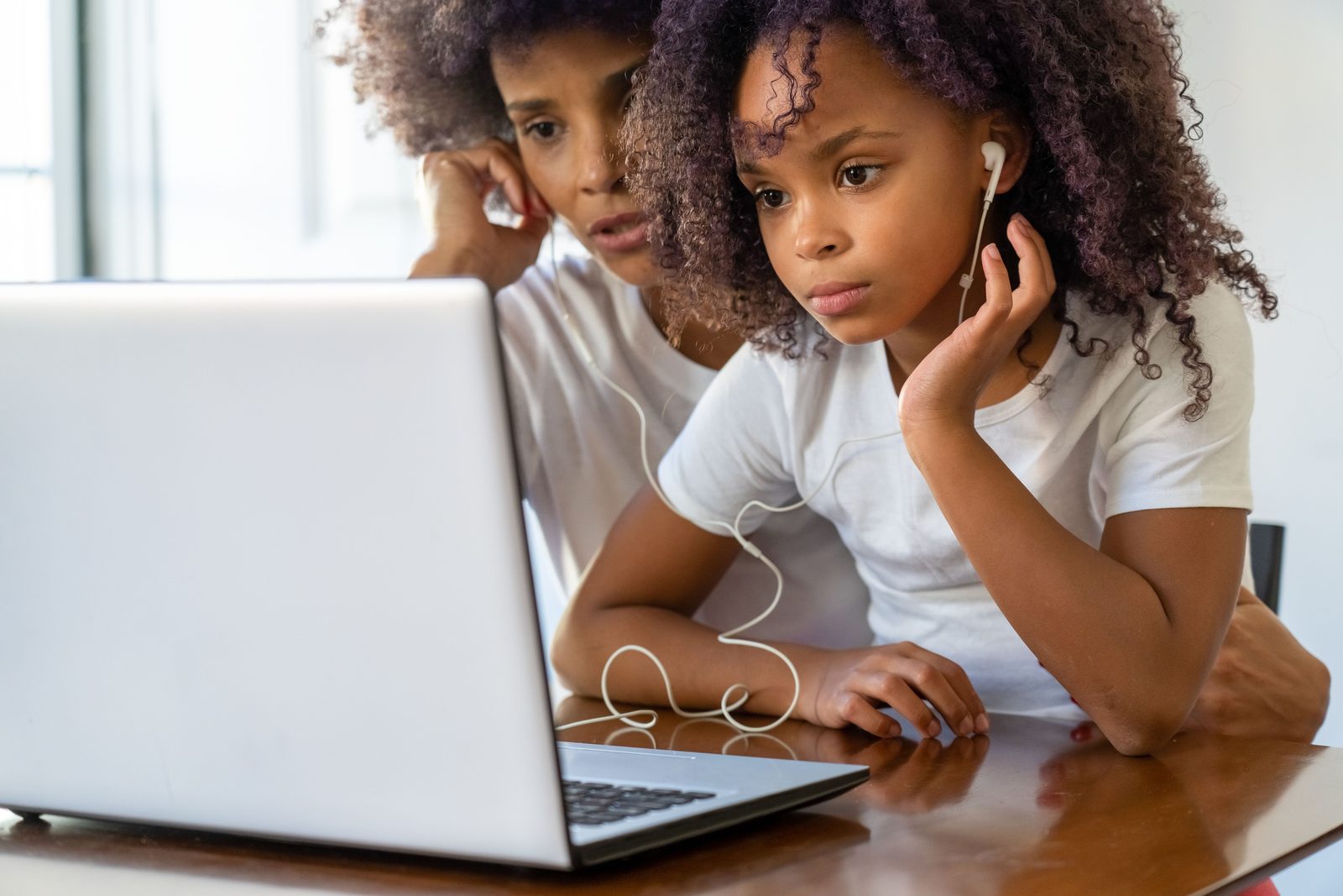 Concerned parent looking at a laptop with a school-age child